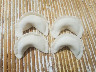 手工饺子摆放在竹制垫子上