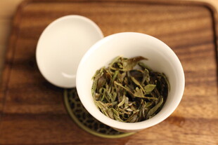 白瓷杯中的嫩绿茶叶