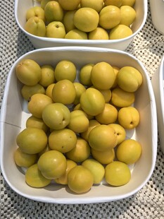 白盘盛放的新鲜黄李子