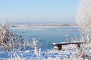 冬日湖畔雪景中的长椅