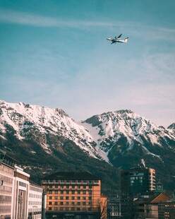 雪山城市上空的飞行飞机