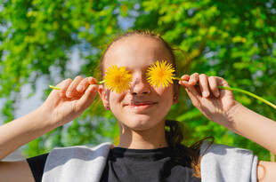 女孩手持花瓣遮眼玩耍