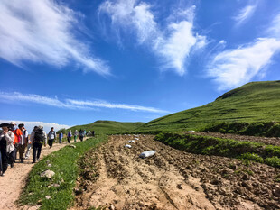 山间徒步队伍穿行美景中