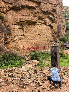 人在岩壁下观察地质景象