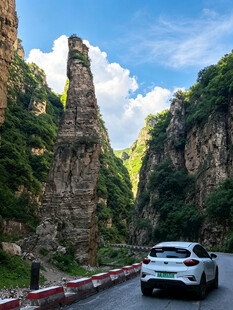 山间公路上行驶的白色汽车