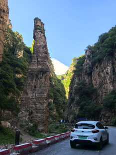 山间公路上行驶的白色汽车