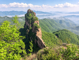 峻峭山峰掩映于葱郁山林