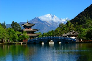湖畔古桥与雪山相映成趣