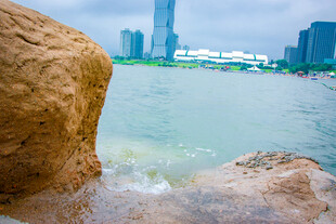 海边巨石与远处城市景观