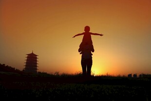 夕阳下张开双臂的人物剪影
