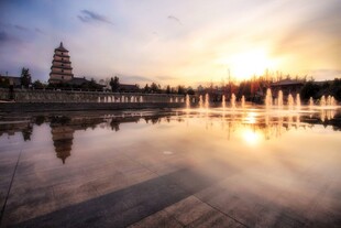 夕阳下古塔映于平静湖面