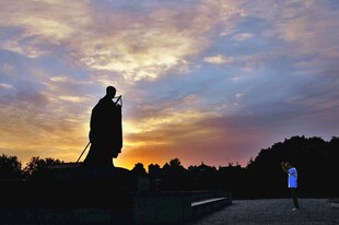 夕阳下的雕像与行人