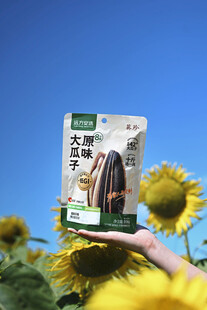 手持瓜子包装于向日葵间