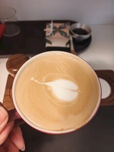 手持拉花咖啡特写