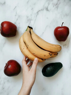 手捧香蕉与多样水果