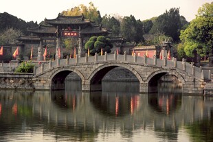 古桥映于中式建筑旁湖水
