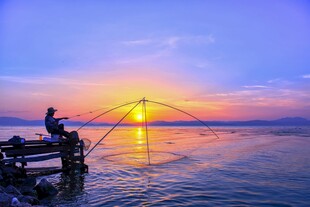 夕阳下的海边垂钓者