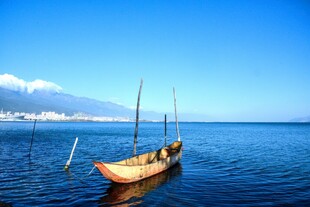 海上孤舟 远方山峦蓝天