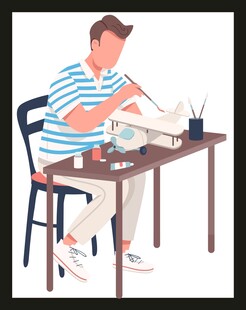 男子桌边专注手工制作