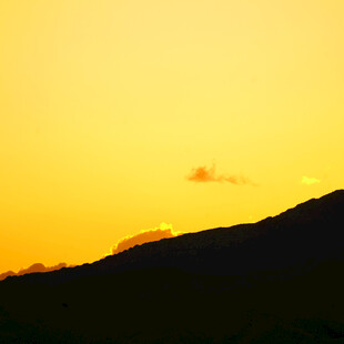 夕阳下的山峦与孤云