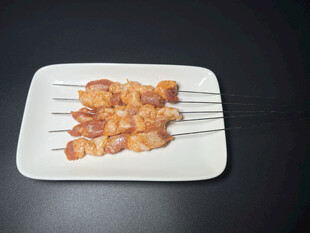 美味鸡肉串摆于白盘上