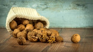 木桌上麻袋中的饱满核桃