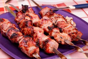 美味烤肉串摆于紫色盘上