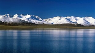 雪山下的静谧蓝色湖泊