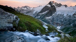 山间溪流伴日暮雪山美景