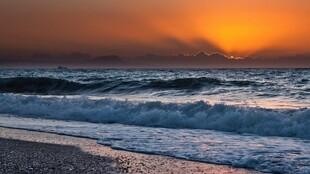 海边日落海浪轻拍沙滩