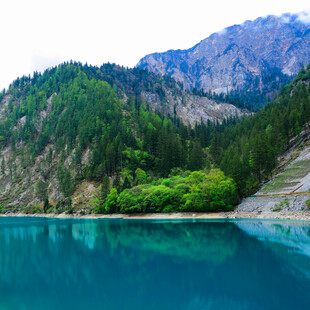 高山下的澄澈碧绿湖泊