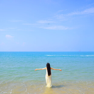 海边女子舒展双臂赏美景