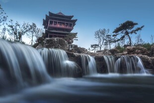 山间飞瀑旁的古韵楼阁