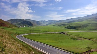 甘南蜿蜒公路穿行于绿野蓝天