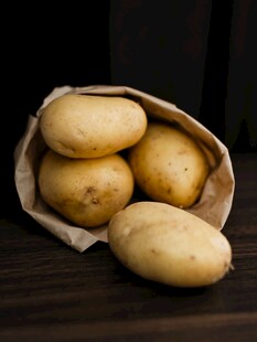 袋装新鲜土豆摆放在木桌