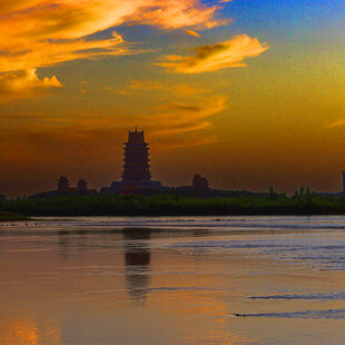 夕阳下的古塔与平静湖面