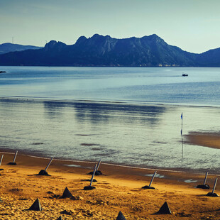 海边沙滩与远处山峦美景