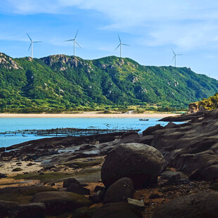 海边青山与风力发电机组景