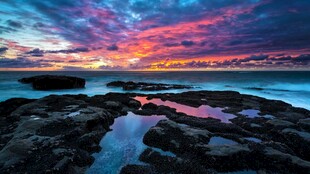 海边绚丽日出下的礁石景观