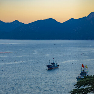黄昏海面的船只与远山