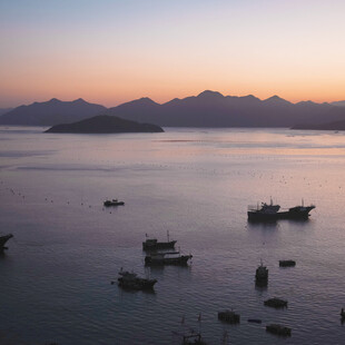 海上暮色中的渔船与远山