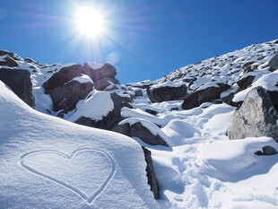 雪山上的阳光与爱心痕迹