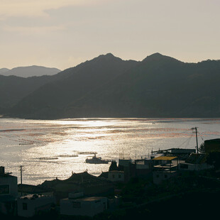 夕阳下的山水与江上船只