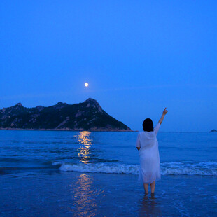 海边女子月夜下的浪漫身影