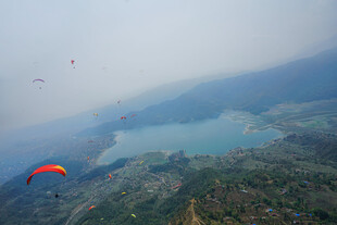 空中俯瞰山水间的滑翔伞