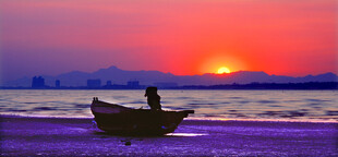 夕阳下的海边孤舟