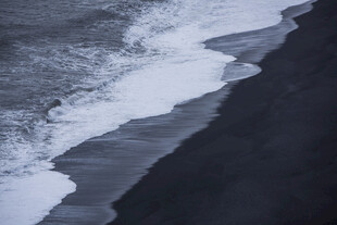 海浪拍打黑色沙滩瞬间