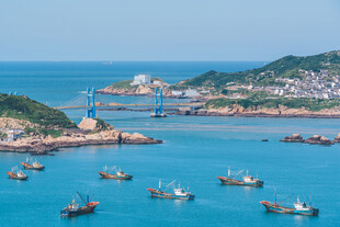 海滨渔村渔船点缀蓝色海湾