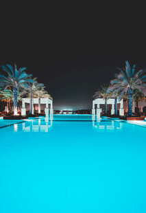 夜晚泳池边的棕榈树美景