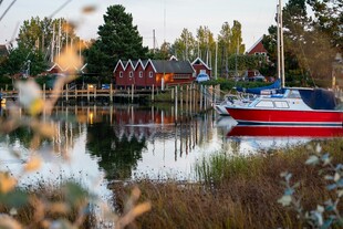 湖畔红船与岸边小屋美景